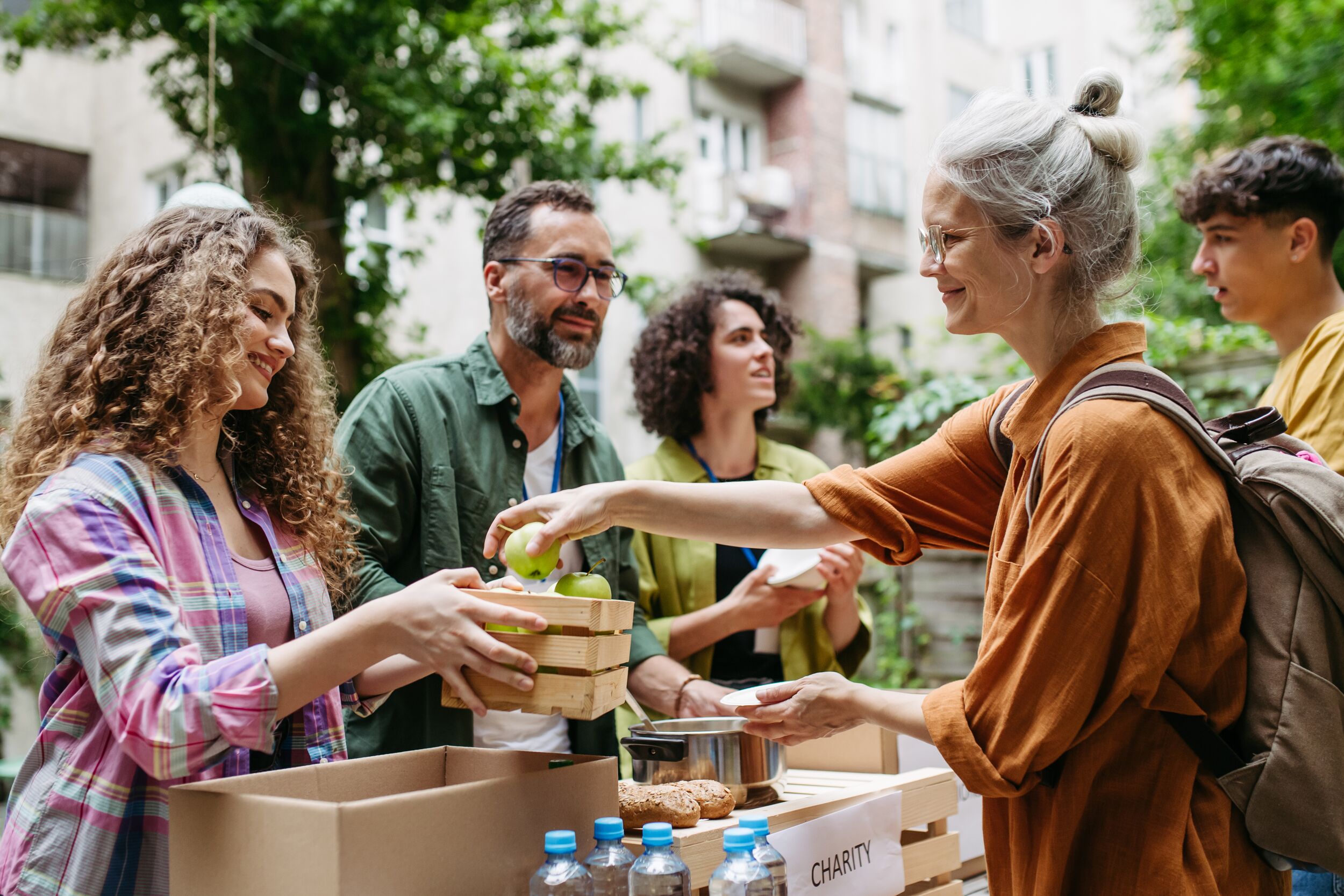Volunteers serving soup to people in need or, people experiencing food insecurity.