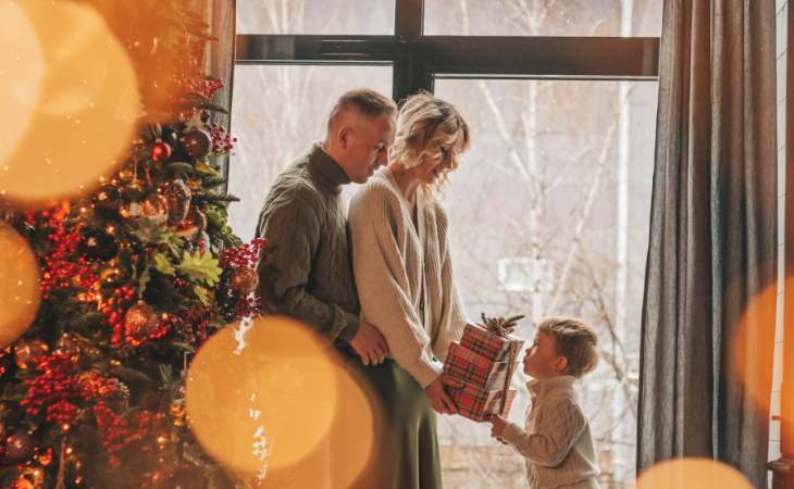 Mother and father giving their son a present on Christmas morning.