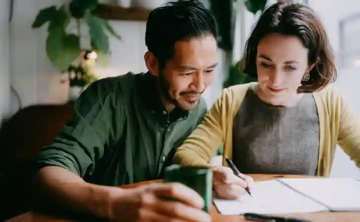 A couple works together to write out a budget.